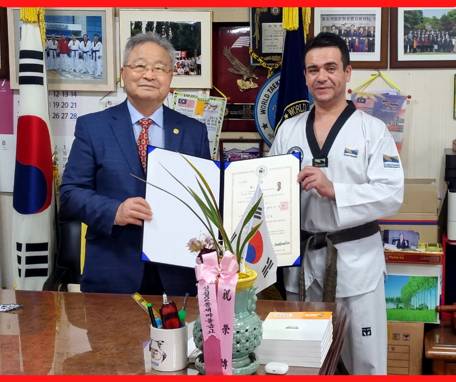 Mestre Alexandre Coelho dos Santos recebendo certificação de 8° Dan das mãos do presidente da World Taekwondo Chang Moo Kwan.